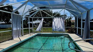 Ein überdachter Pool, über dem ein klarer, blauer Himmel zu sehen ist.