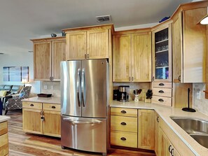 Enjoy cooking in this well-equipped kitchen with a refrigerator, sink, and cabinetry.