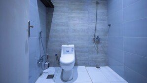A modern bathroom with a white toilet, a shower, and a towel rack. - Centrally Located Self Checkin Luxury  Apartment (Riyadh)
