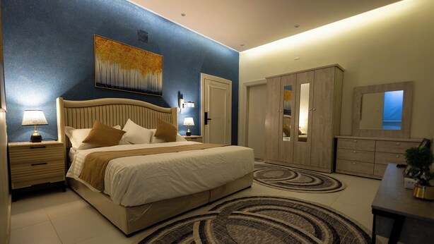 A bedroom with a bed, nightstands, a dresser, and a mirror. - Centrally Located Self Checkin Luxury  Apartment (Riyadh)