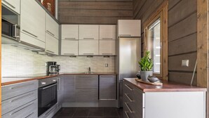 Une cuisine moderne dotée d’appareils électroménagers en acier inoxydable, de meubles en bois et d’une grande fenêtre.