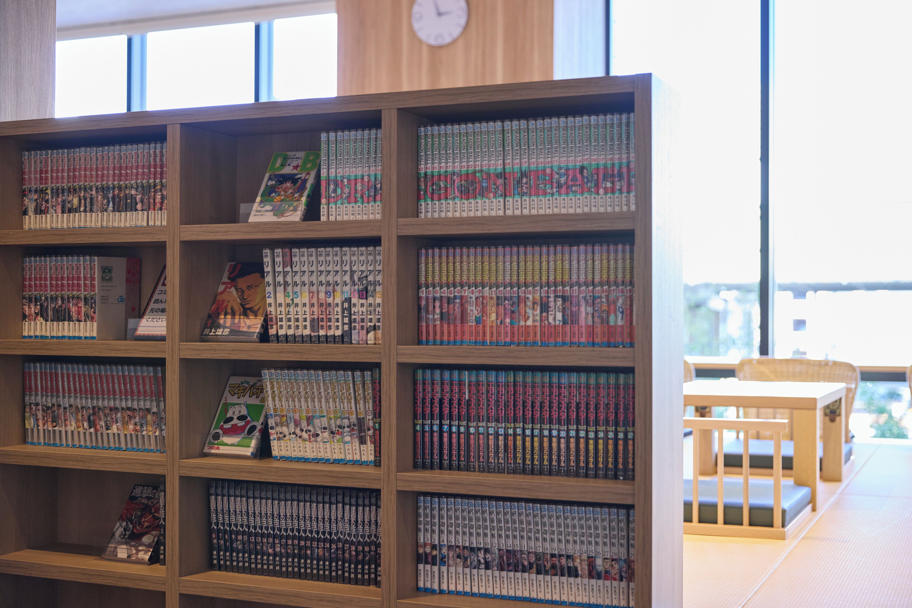 Una estantería repleta de volúmenes de manga en un ambiente de biblioteca.