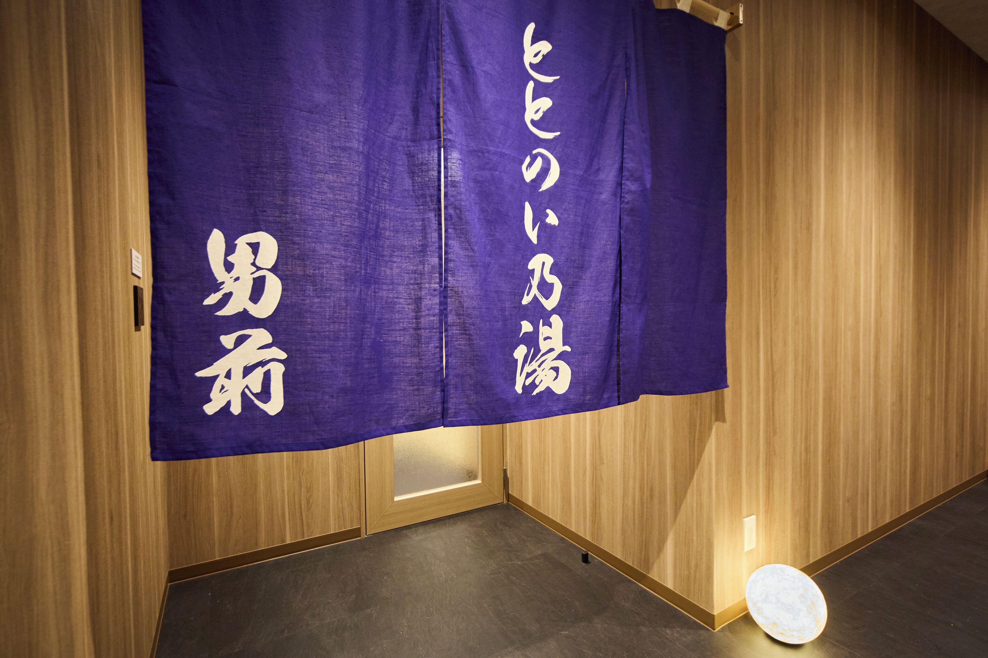 Een kamer met houten lambrisering en een paarse banner met witte tekst.
