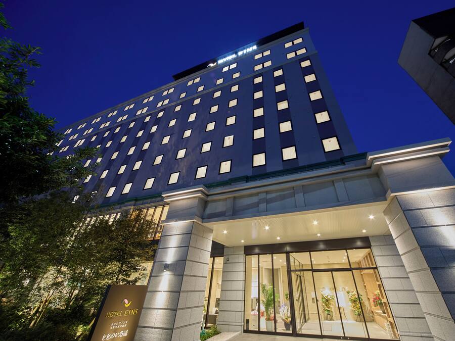 A modern hotel building with a prominent entrance and illuminated signage.