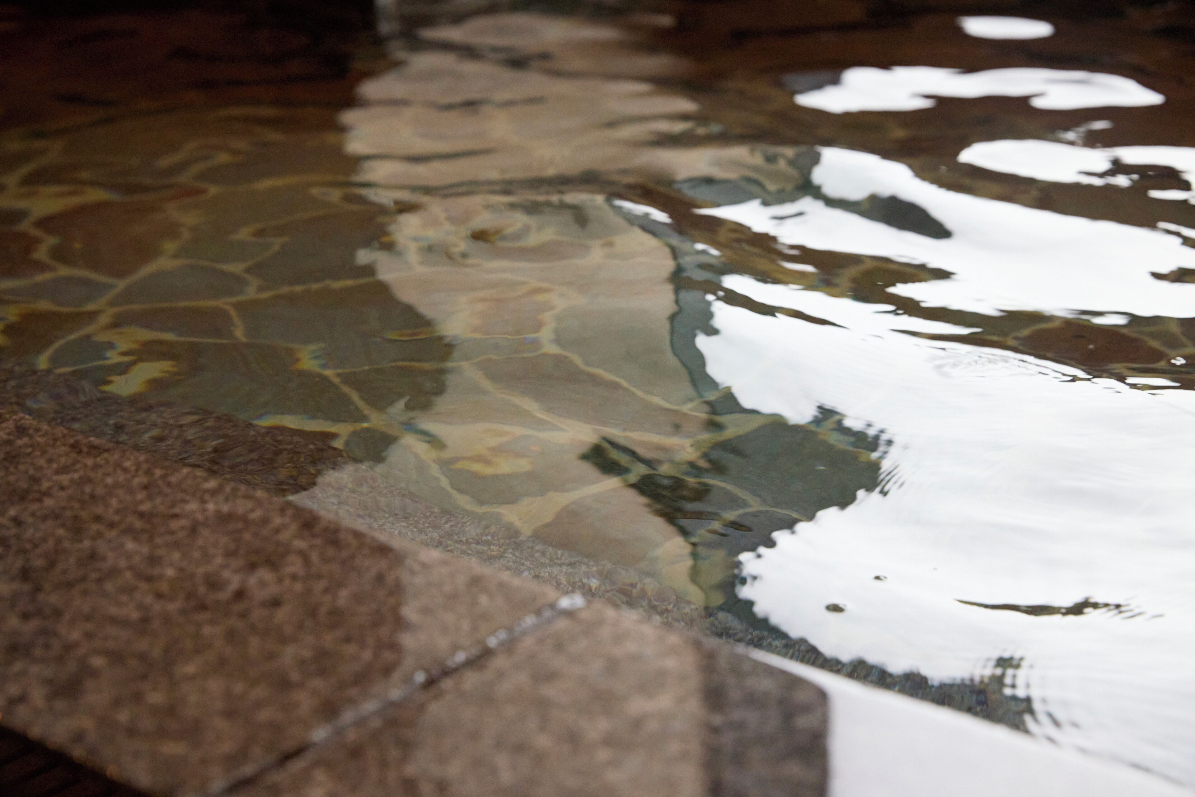 A stone pool with clear water reflecting the surrounding stonework.