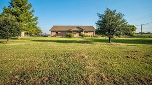 A single-story house with a sloped roof, a front porch, and a well-maintained lawn.
