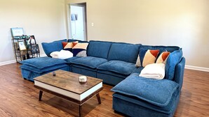 A living room with a sectional sofa, a coffee table, and a small side table.