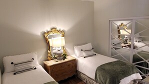 A bedroom with two beds, a ceiling fan, a nightstand with a lamp, and a mirror. - Charming 2bedroom villa in the terrace level of the host home,Completely private (Hoschton)