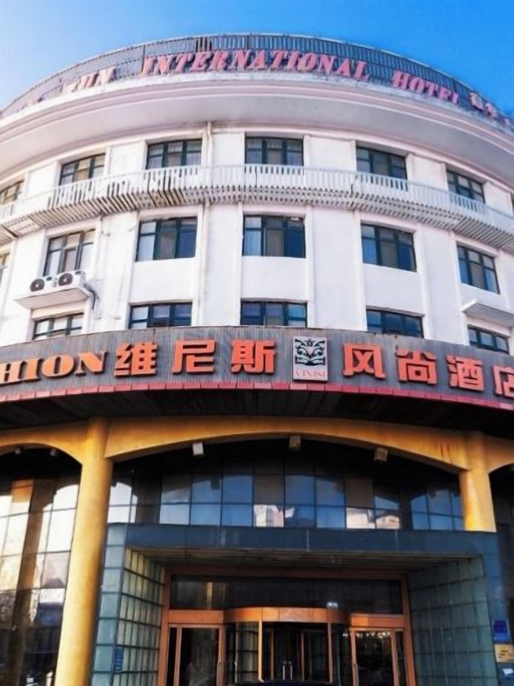 A hotel with a prominent signboard, a large entrance, and a circular design.