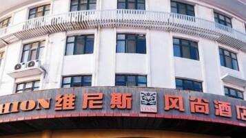 A hotel with a prominent signboard, a large entrance, and a circular design.