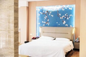 A hotel room with a bed, a nightstand, a wall-mounted TV, and a window with a view. - Vines Fashion Hotel Lianyungang (Lianyungang)