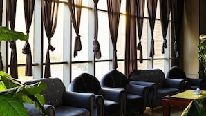 A room with four dark blue upholstered chairs arranged around a wooden coffee table.