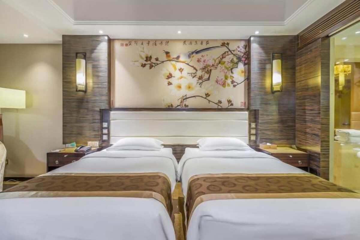 A hotel room with two beds, a large wall mural, and a modern design.