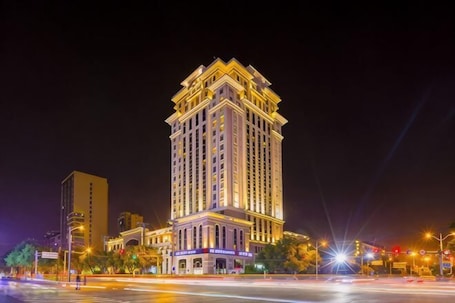 A high-rise hotel with multiple floors, a prominent entrance, and a well-lit facade.. Kunlun Hotel (Hengshui Zhongxin Street)