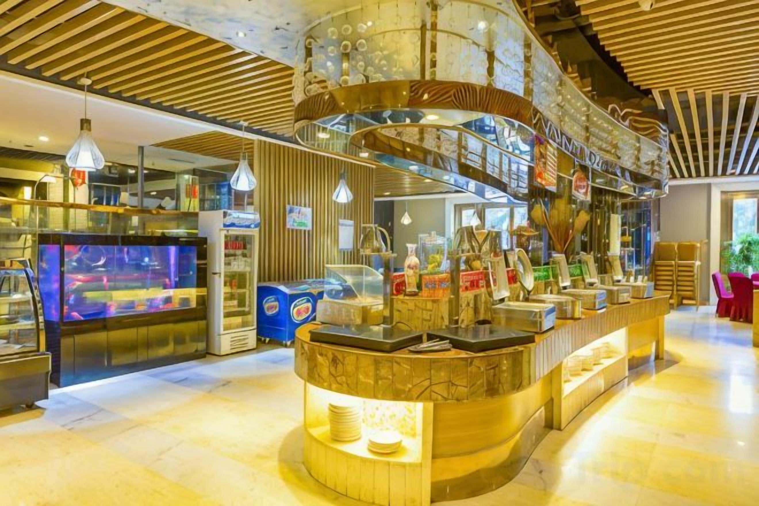 A modern bar area with a curved counter, overhead lighting, and a visible aquarium.