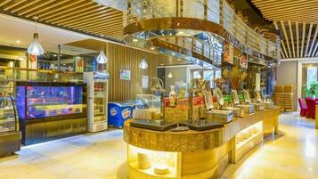 A modern bar area with a curved counter, overhead lighting, and a visible aquarium.