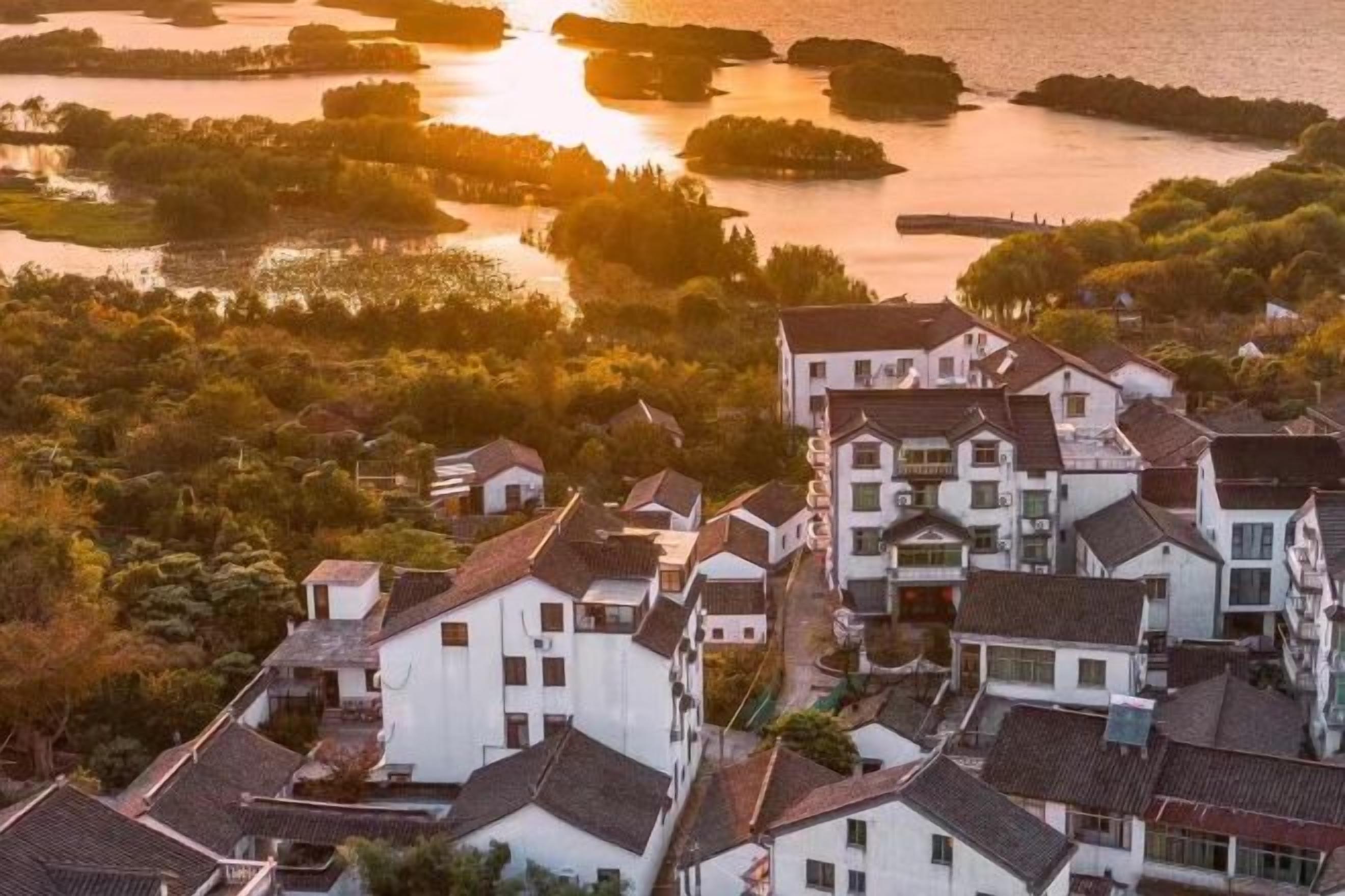 Un quartier résidentiel à l’architecture traditionnelle, entouré d’étendues d’eau et de verdure.