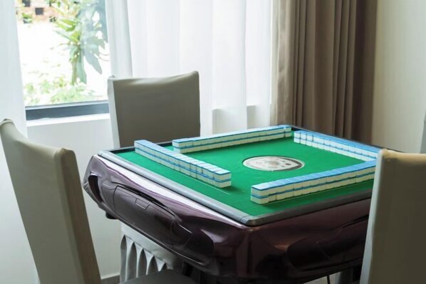 A room with a green pool table, beige chairs, and a window with curtains. - Qianyu Qianxun B&B ((Sanshan Island Scenic Area Branch) (Suzhou)