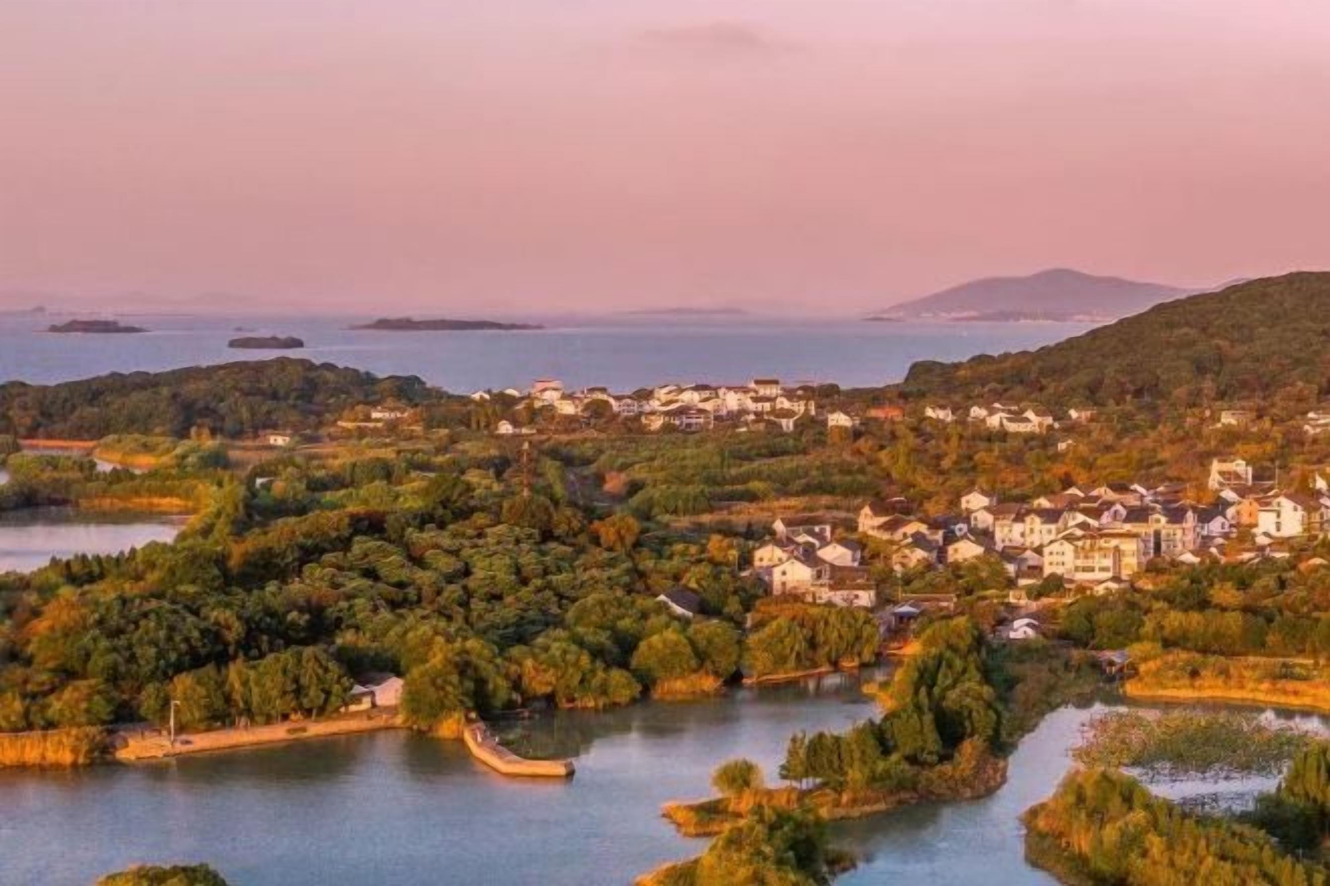 A coastal town with a river, buildings, and greenery.