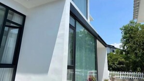 Un edificio moderno con ventanas amplias y fachada blanca.