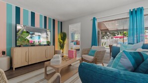 A modern living room with a flat-screen TV, a wooden cabinet, a sofa, and a coffee table.