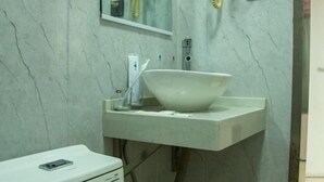 Un baño con un lavabo blanco, un espejo y un inodoro.