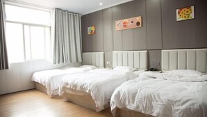Una habitación de hotel con dos camas, un ventanal con cortinas y obras de arte en las paredes.