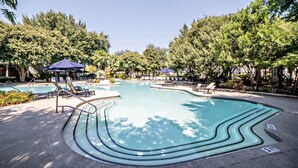 A swimming pool with multiple lanes, surrounded by lounge chairs and umbrellas. - Homey Modern 3BR Retreat w/Resort Pool (Austin)