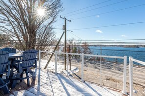 A deck with outdoor seating and a view of a body of water. - Steps to Beach: Lake-View Laconia Getaway! (Laconia)