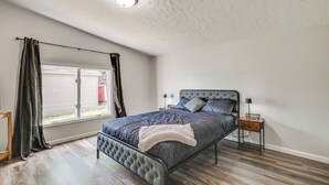 A bedroom with a bed, a nightstand, a window with curtains, and a ceiling light. - Near Hiking & Fishing: Dale Home w/ Deck! (Dale)