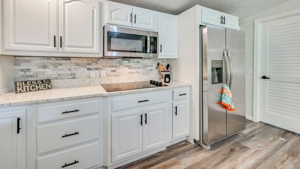 A kitchen with white cabinets, a stainless steel refrigerator, and a microwave. - Near Hiking & Fishing: Dale Home w/ Deck! (Dale)