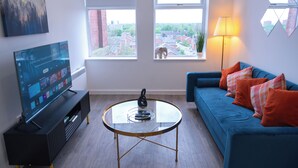 Una sala de estar moderna con televisor, sofá y mesa de centro.
