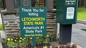 A sign thanking visitors for voting for Letchworth State Park, America's #1 State Park, and a payment kiosk with instructions for credit card and passport payments.