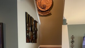 A staircase with wooden steps and a decorative wall piece above it.