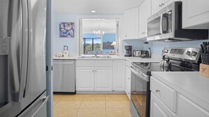 A modern kitchen with white cabinets, stainless steel appliances, and a view to the outside. - Fairway Haven – Minutes to Beach & Harbour Town (Hilton Head Island)