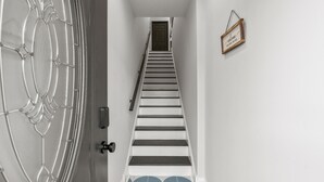 Una escalera con una puerta decorativa y un cartel en la pared.