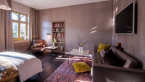A modern living room with a sofa, armchair, coffee table, and bookshelf.
