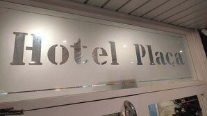 Un cartel con el texto 'Hotel Plaza' que indica el nombre del establecimiento.
