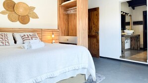 A bedroom with a bed, bedside table, and a wooden wardrobe. - Casa com piscina Praia da Vila Nova (Imbituba)