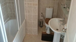 Um banheiro com banheira, vaso sanitário e pia.
