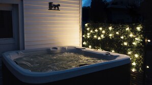 A hot tub with water, a house, and a tree with lights. - 2 Min Walk to Windham Town | Hot Tub | Fire Pit (Windham)