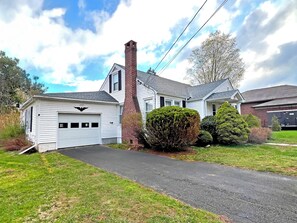 A two-story house with a garage, a brick chimney, and a well-maintained lawn. - 2 Min Walk to Windham Town | Hot Tub | Fire Pit (Windham)