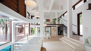 Un intérieur spacieux et moderne, doté d’une grande cuisine ouverte, d’un coin repas et d’un escalier menant à l’étage supérieur.