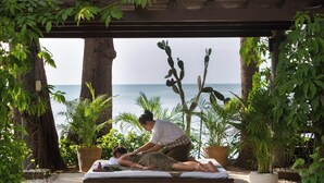 Une séance de massage dans un belvédère en bois offrant une vue sur la mer.