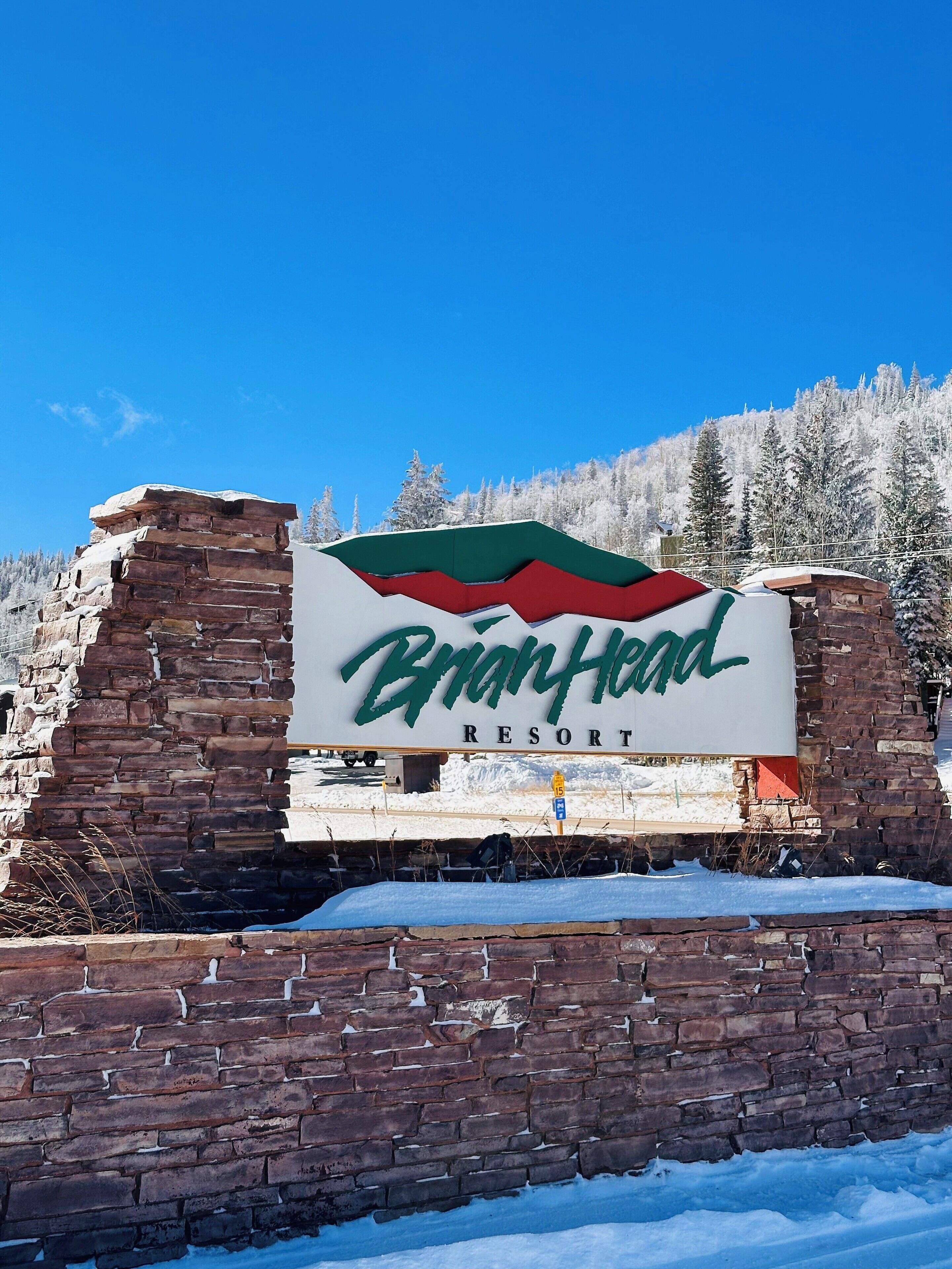 A sign for Brandy Head Resort with a mountainous backdrop.