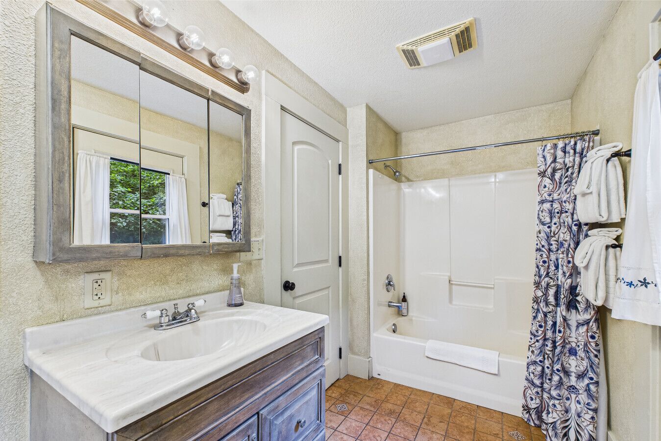 A bathroom with a double sink vanity, a large mirror, a shower with a glass door, and a towel rack.