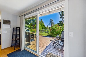 A modern room with a sliding glass door leading to an outdoor deck. - Hill Street Retreat - Near Cal Poly, Redwoods, & Arcata Plaza (Arcata)