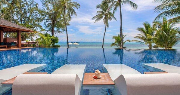 Une piscine avec des chaises longues et vue sur l’océan.