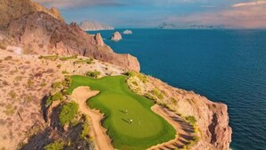 Un campo de golf costero con vistas despejadas al océano y acantilados rocosos.