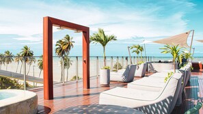 A sun deck with lounge chairs, a pool, and a view of the beach and ocean. - Setai Yacht Premium II - By Almare Flats (João Pessoa)